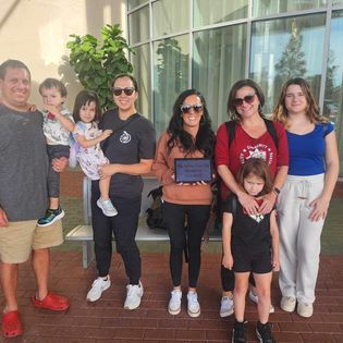 Family with children standing outside hotel on vacation